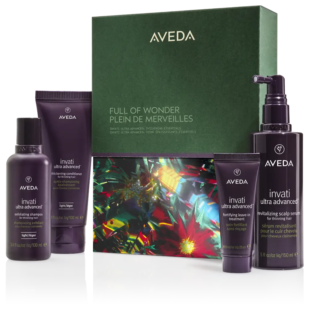 A gift box labeled “Aveda Full of Wonder” is displayed with four Aveda Invati Ultra Advanced hair care products in purple packaging arranged in front of it. - K. Charles & Co. in San Antonio and Schertz, TX