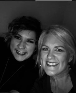 Two women smiling at the camera in a black and white photo. one has short hair and earrings, the other sports a nose ring. - K. Charles & Co. in San Antonio and Schertz, TX