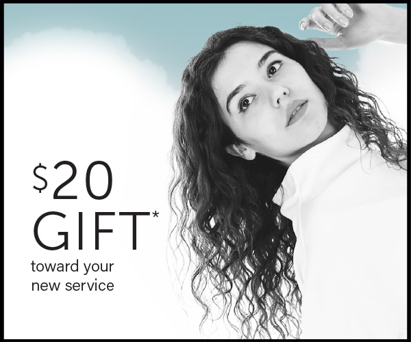 Woman with curly hair looking upwards, a "$20 gift towards your new service" text overlay on the left side. - K. Charles & Co. in San Antonio and Schertz, TX