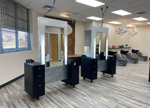 Interior of a modern hair salon showing styling stations with mirrors, chairs, and a waxing area with basins in the background. - K. Charles & Co. in San Antonio and Schertz, TX