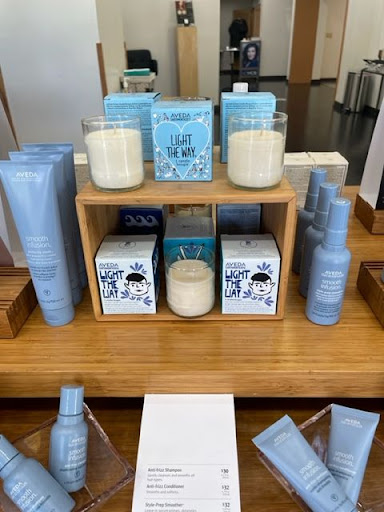 Display of aveda haircare products arranged on wooden shelves in a salon, featuring shampoos, conditioners, and styling products. - K. Charles & Co. in San Antonio and Schertz, TX