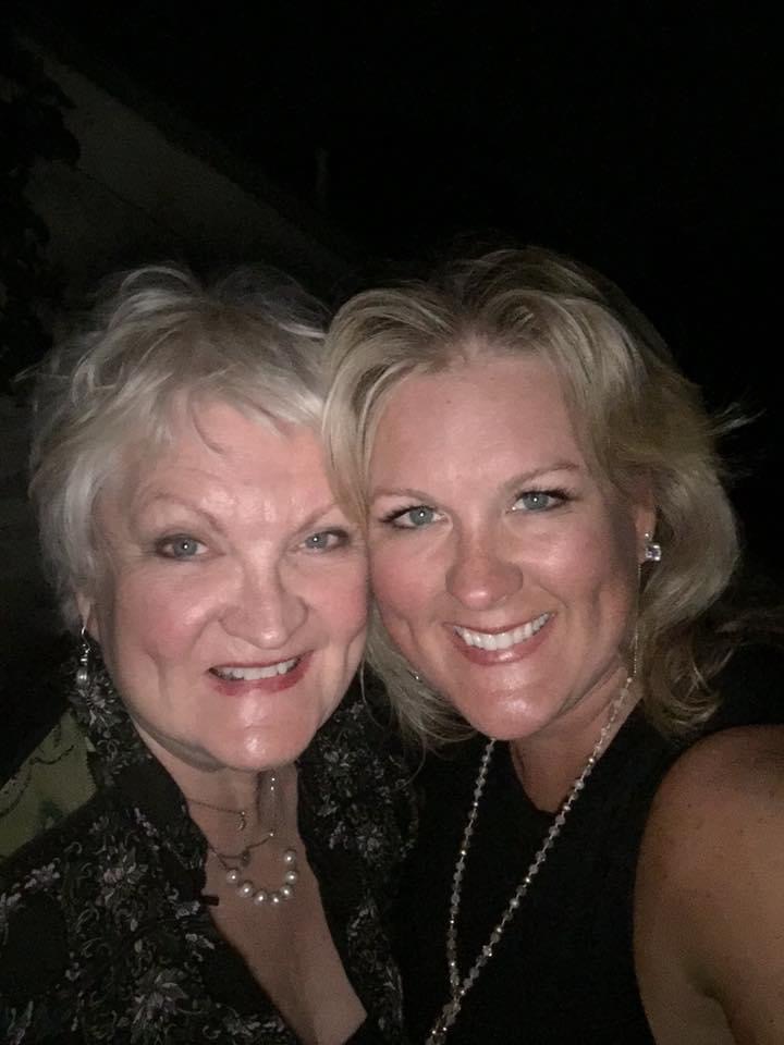 Two women smiling for a selfie at night, one with short blonde hair and the other with medium-length blonde hair, both wearing dark outfits and pearl earrings. - K. Charles & Co. in San Antonio and Schertz, TX