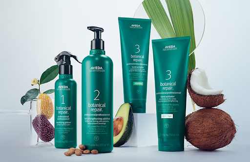 A set of Aveda botanical repair hair care products, including shampoo, conditioner, and treatments, displayed with natural ingredients like avocados, coconuts, and almonds. - K. Charles & Co. in San Antonio and Schertz, TX