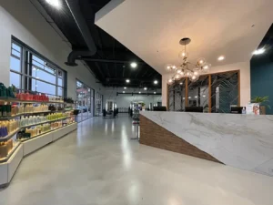 Modern salon interior featuring a large reception desk, contemporary lighting, product displays on the left, and styling stations visible in the background. - K. Charles & Co. in San Antonio and Schertz, TX
