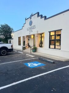 Wheelchair-accessible parking space in front of K. Charles & Co. building with large windows and a ramp by the entrance. - K. Charles & Co. in San Antonio, TX